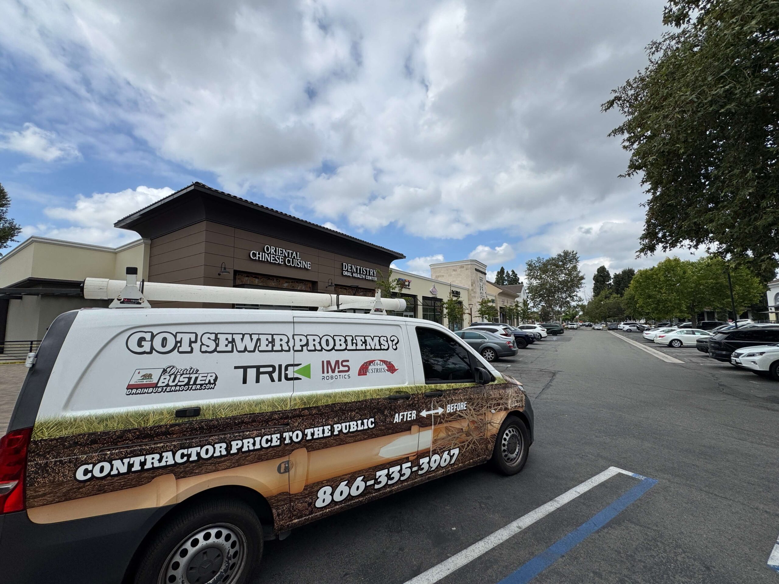 Drain Buster Rooter & Plumbing service truck parked outside a commercial building for professional plumbing services